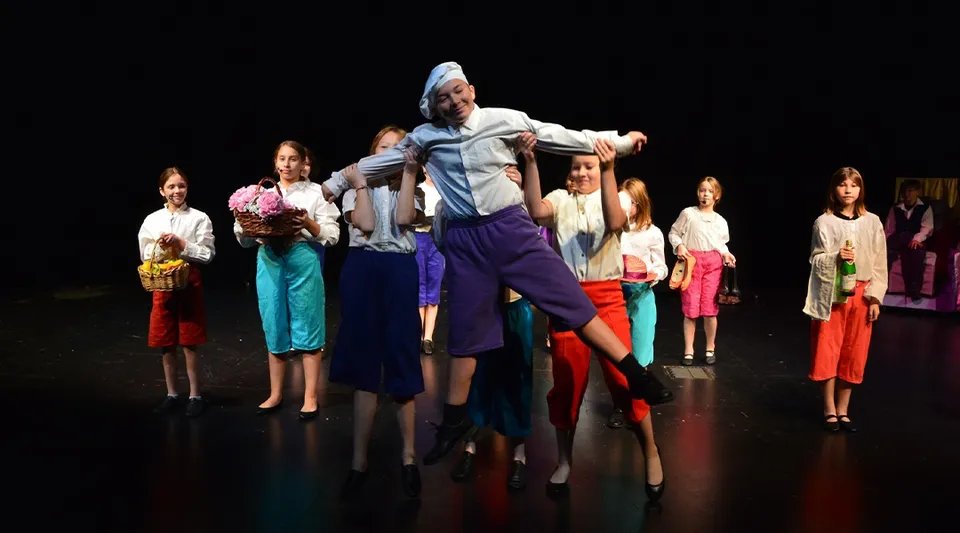 Gli studenti della Charles Wright Academy recitano in uno spettacolo teatrale su un palco.