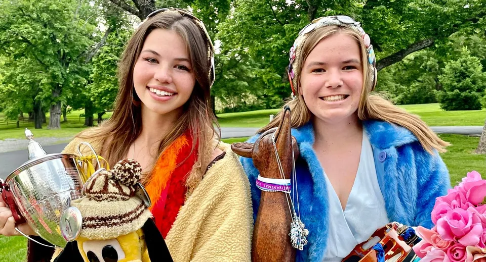 Due studentesse della Foxcroft School sono in piedi nel parco davanti ad alberi verdi e sorridono alla fotocamera.
