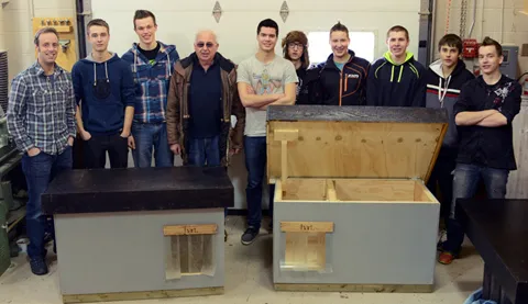 Gruppenfoto von Schülern mit den Hundehäusern die sie gebaut haben