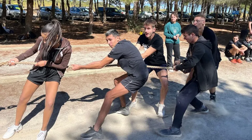 Un gruppo di studenti e studentesse si raccoglie nell'area esterna alberata nel campus del Lycée Notre Dame de Bon Secours.