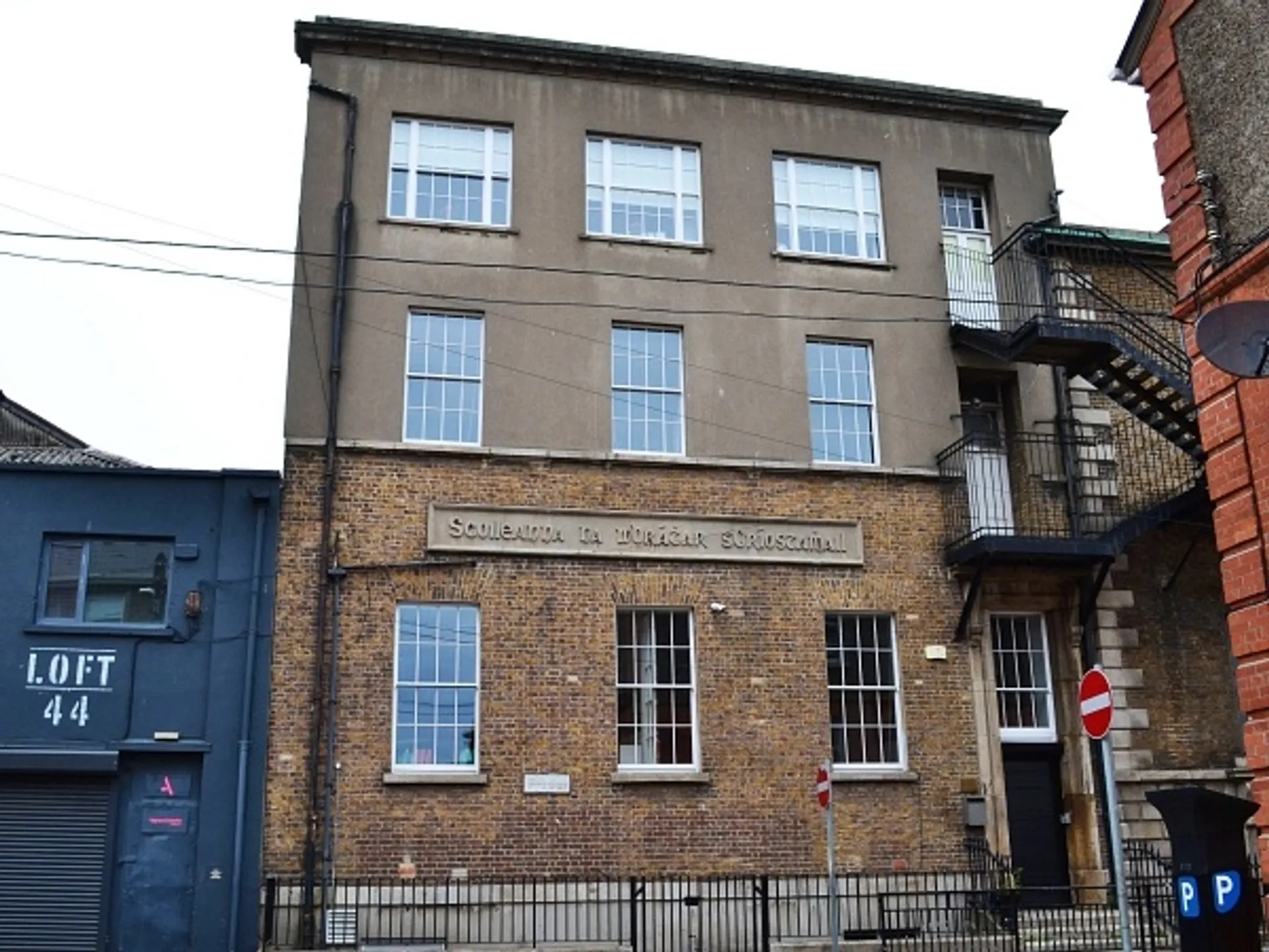L'edificio in mattoni a più piani con grandi finestre nel campus della CBS Westland Row in un ambiente urbano.