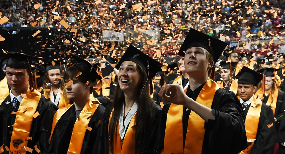 I diplomati del Coláiste an Chreagáin festeggiano il loro diploma con toghe gialle e nere sotto una pioggia di coriandoli.