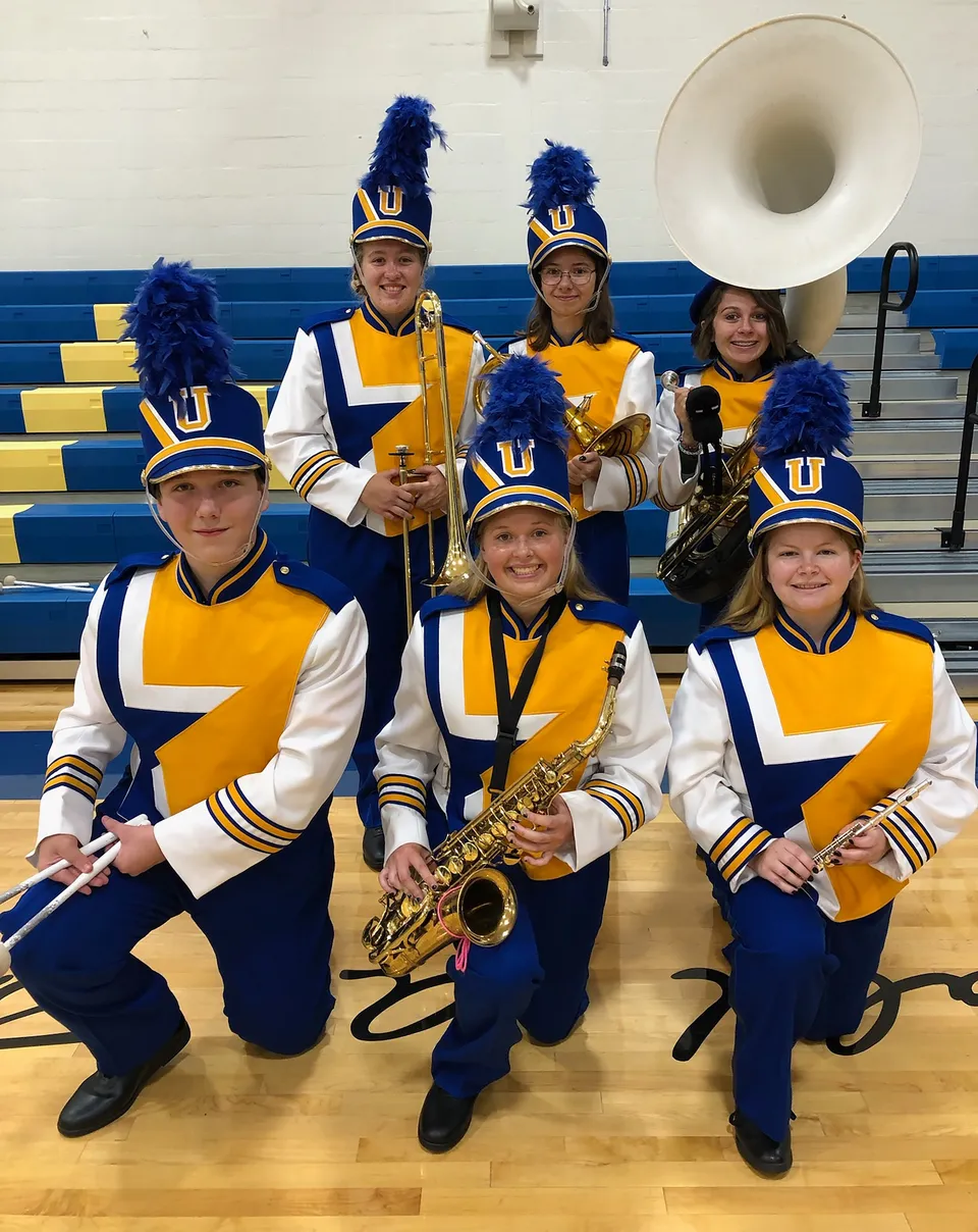 Un gruppo di cheerleader della Union High School indossa uniformi uniformi gialle e blu nella palestra.