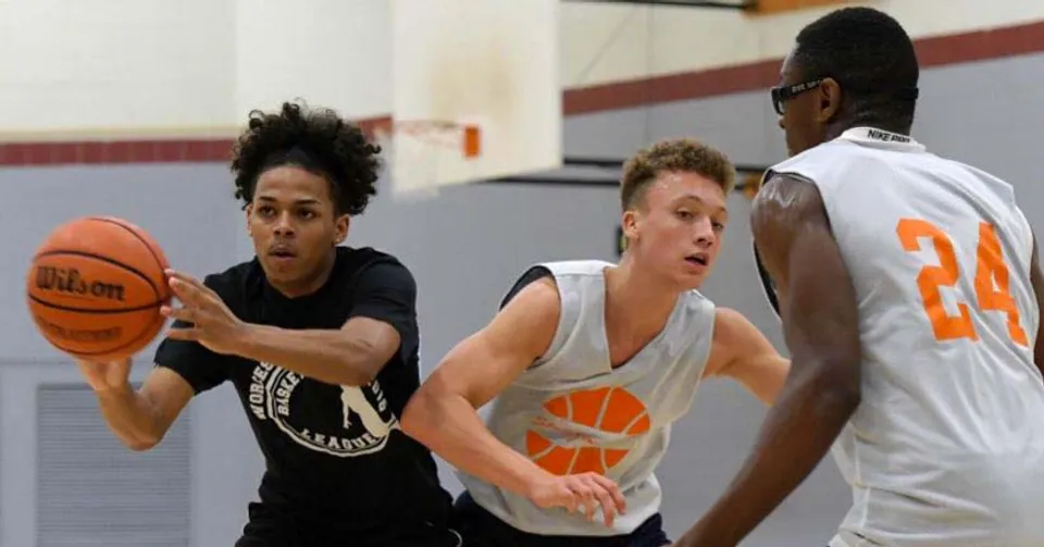 Tre giovani giocatrici e giocatori di basket si allenano sul campo da basket della Worcester Academy.