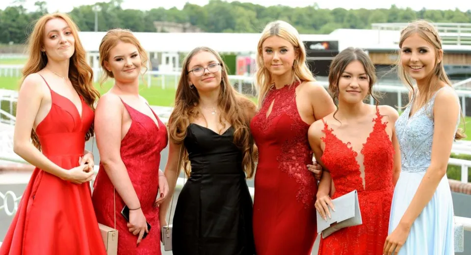 Un gruppo di studentesse della Woldingham School posa all'aperto davanti a uno sfondo boscoso.
