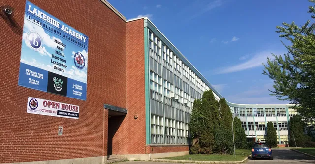 L'edificio in mattoni della Lakeside Academy è circondato da alberi sotto un cielo azzurro e limpido.