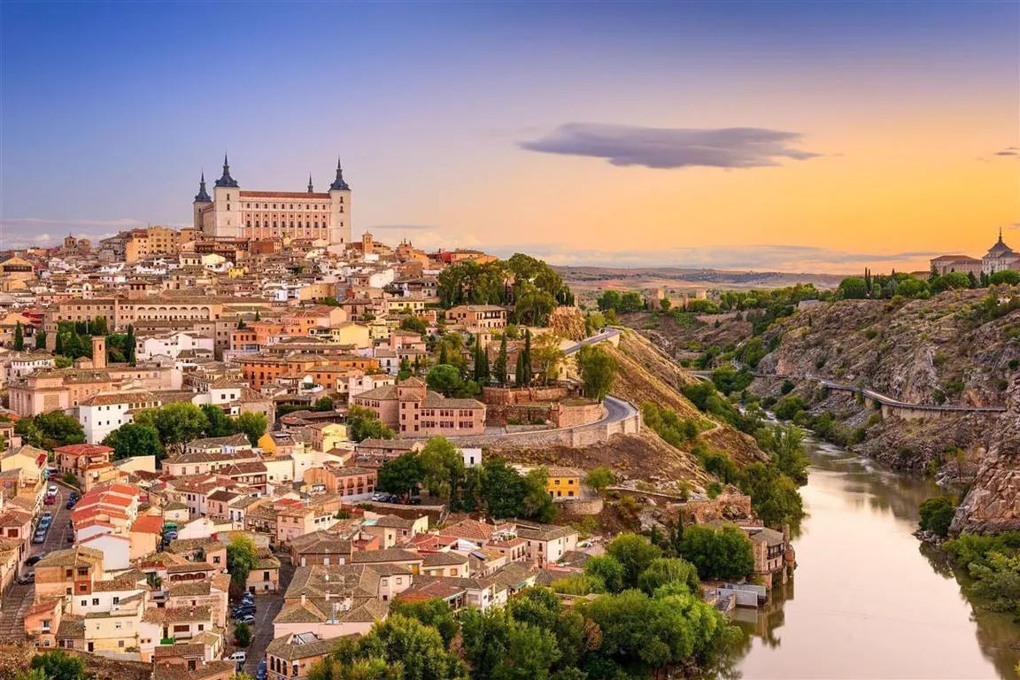 Blick über die Altstadt von Toledo mit dem Alcázar im Abendlicht