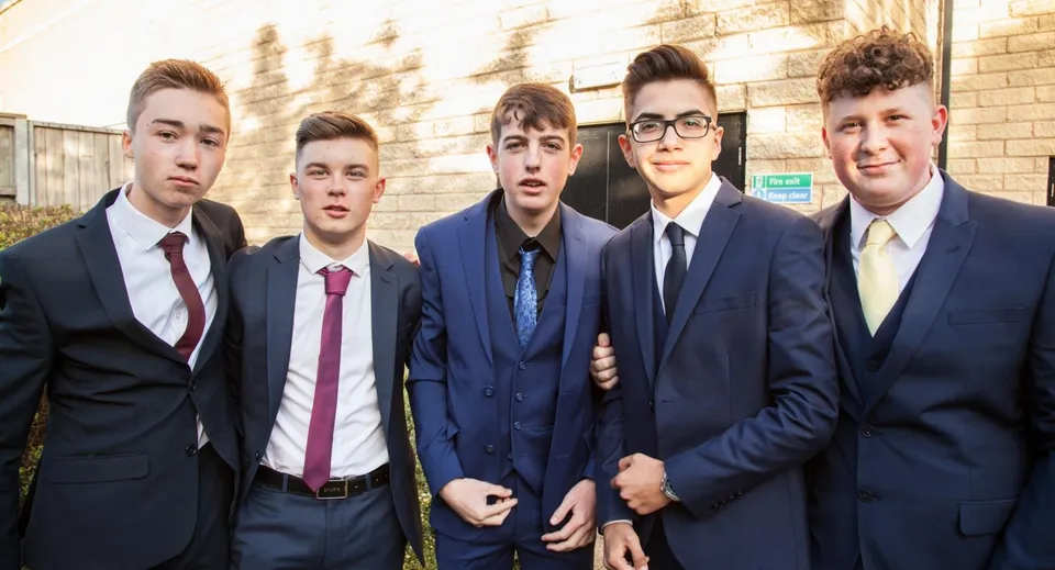 Un gruppo di cinque studenti della Napier Boys High School è in piedi davanti a un edificio in mattoni.
