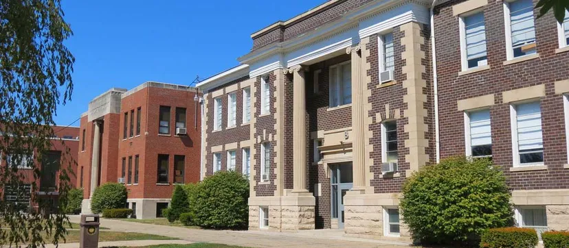 L'edificio in mattoni a più piani della Vernon Township High School si trova su un'area verde con alberi.