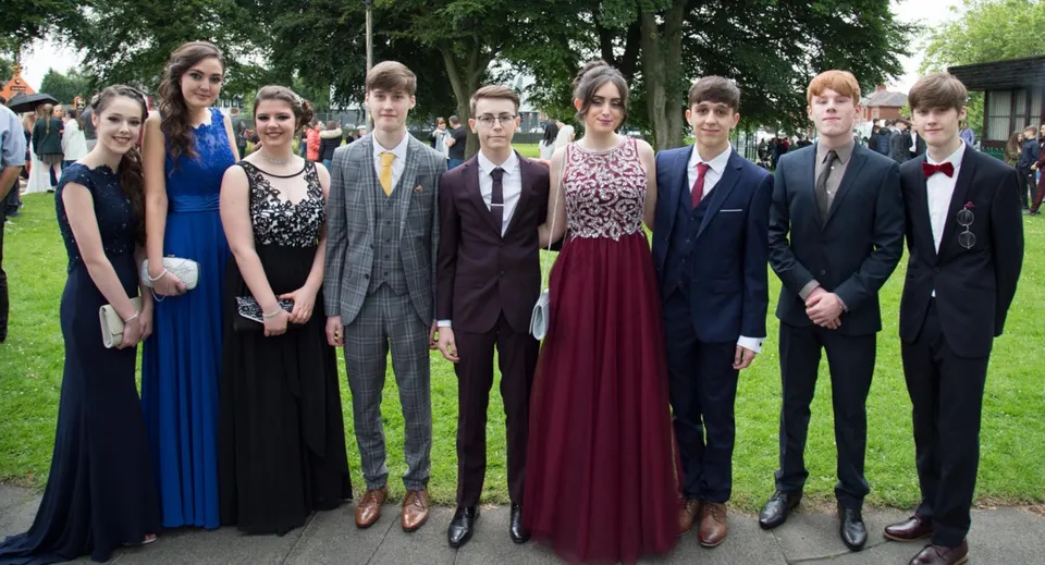 Un gruppo di studenti del St. Edmund’s College si trova insieme in un'area simile a un parco con alberi sullo sfondo.