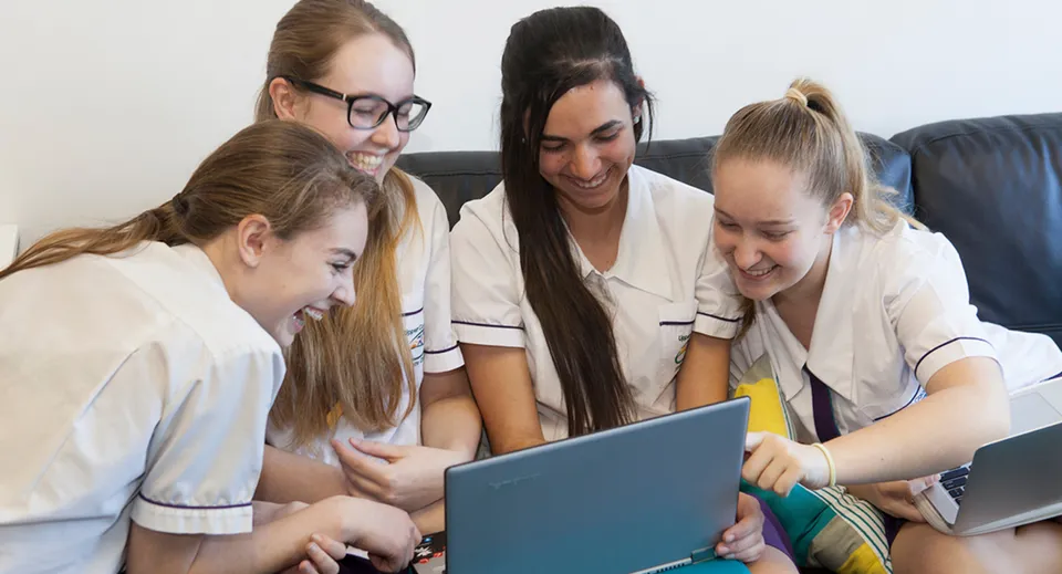Un gruppo di studentesse dell'Upper Coomera State College lavora insieme a un laptop.