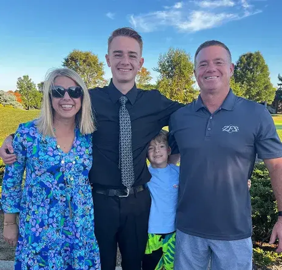 Famiglia americana sorridente all'aperto con due ragazzi in una giornata di sole