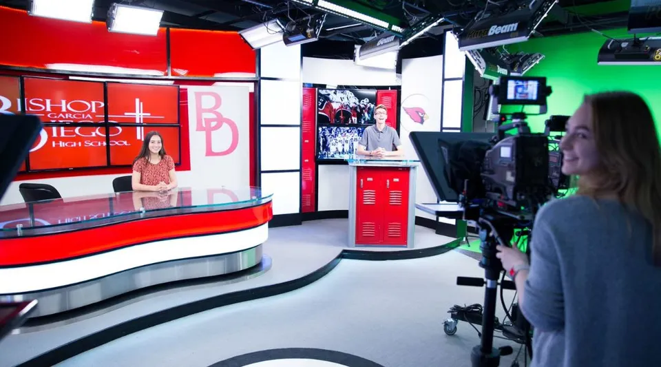 Un presentatore del telegiornale si trova nello studio televisivo del campus della Bishop Garcia Diego High School.