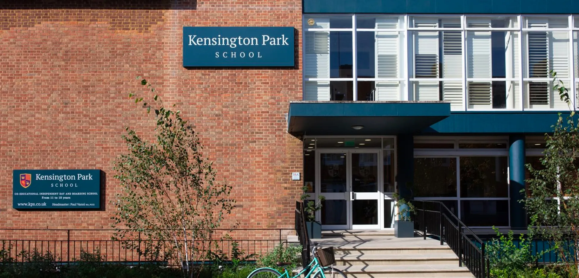 L'edificio in mattoni della Kensington Park School con ingresso e scalinata è circondato da piante verdi.