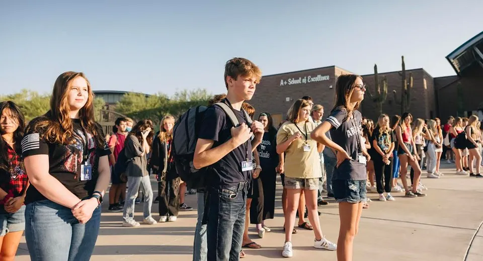 Un gruppo di studenti si trova all'aperto davanti ad alcuni edifici sul campus del Cave Creek Unified School District.