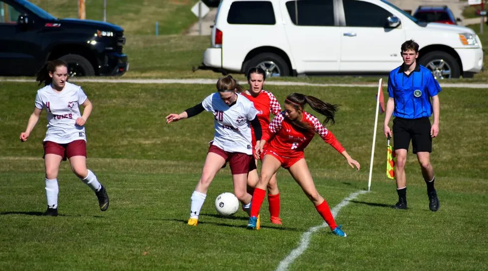 Giovani calciatrici durante una partita sul campo in erba della Wayland Academy.