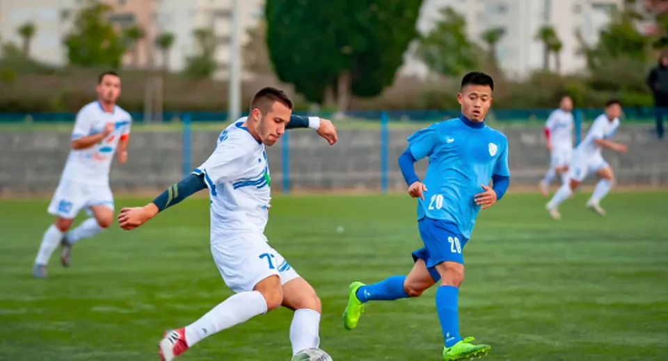 Due studenti giocano a calcio sul campo sportivo del Bournemouth & Poole College.