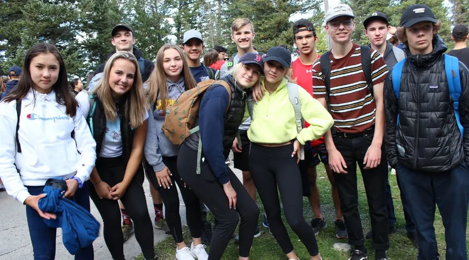 Un gruppo di studenti e studentesse si trova all'esterno, in un ambiente simile a un parco, nel campus della National Sport School.