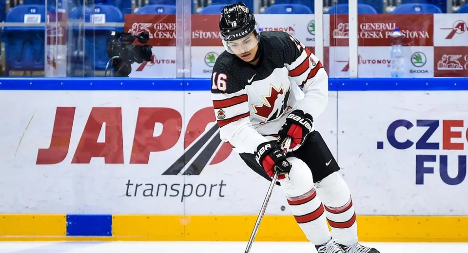 Un giocatore di hockey su ghiaccio in divisa bianca e rossa mentre patina sul ghiaccio nel campus della Leo Hayes High School.