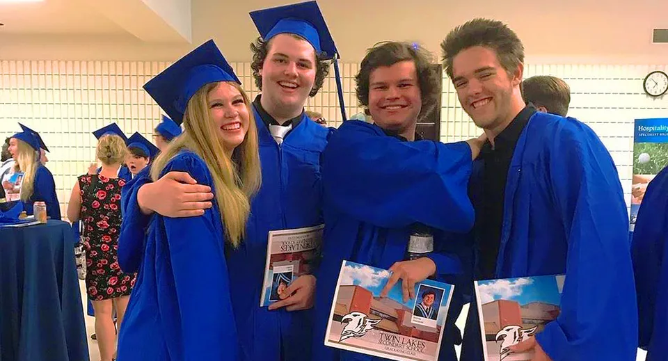 Un gruppo di quattro studenti della Twin Lakes Secondary School in toga blu da diploma posa insieme.