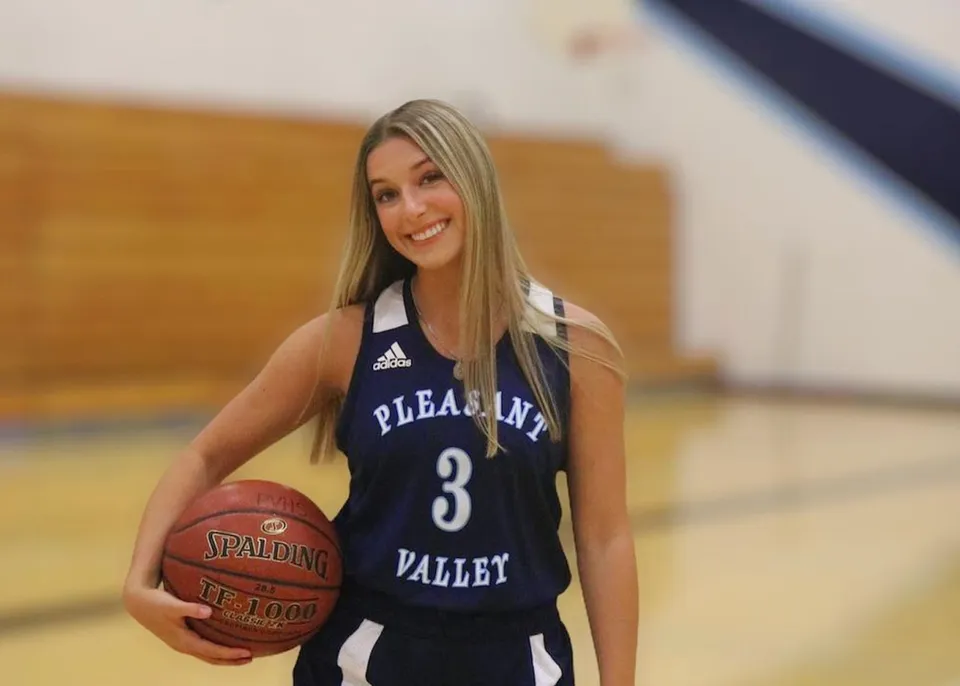 Una studentessa della Pleasant Valley High School è in palestra con un pallone da basket.