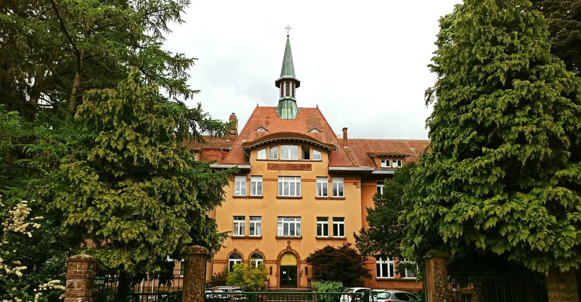L'edificio del Lycée Saint Antoine, con un'evidente torre, sorge circondato da alberi verdi.