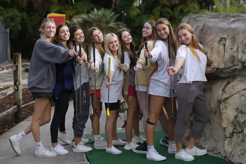 Un gruppo di studentesse si trova insieme all'aperto davanti a uno sfondo roccioso nel campus della The King's Academy.