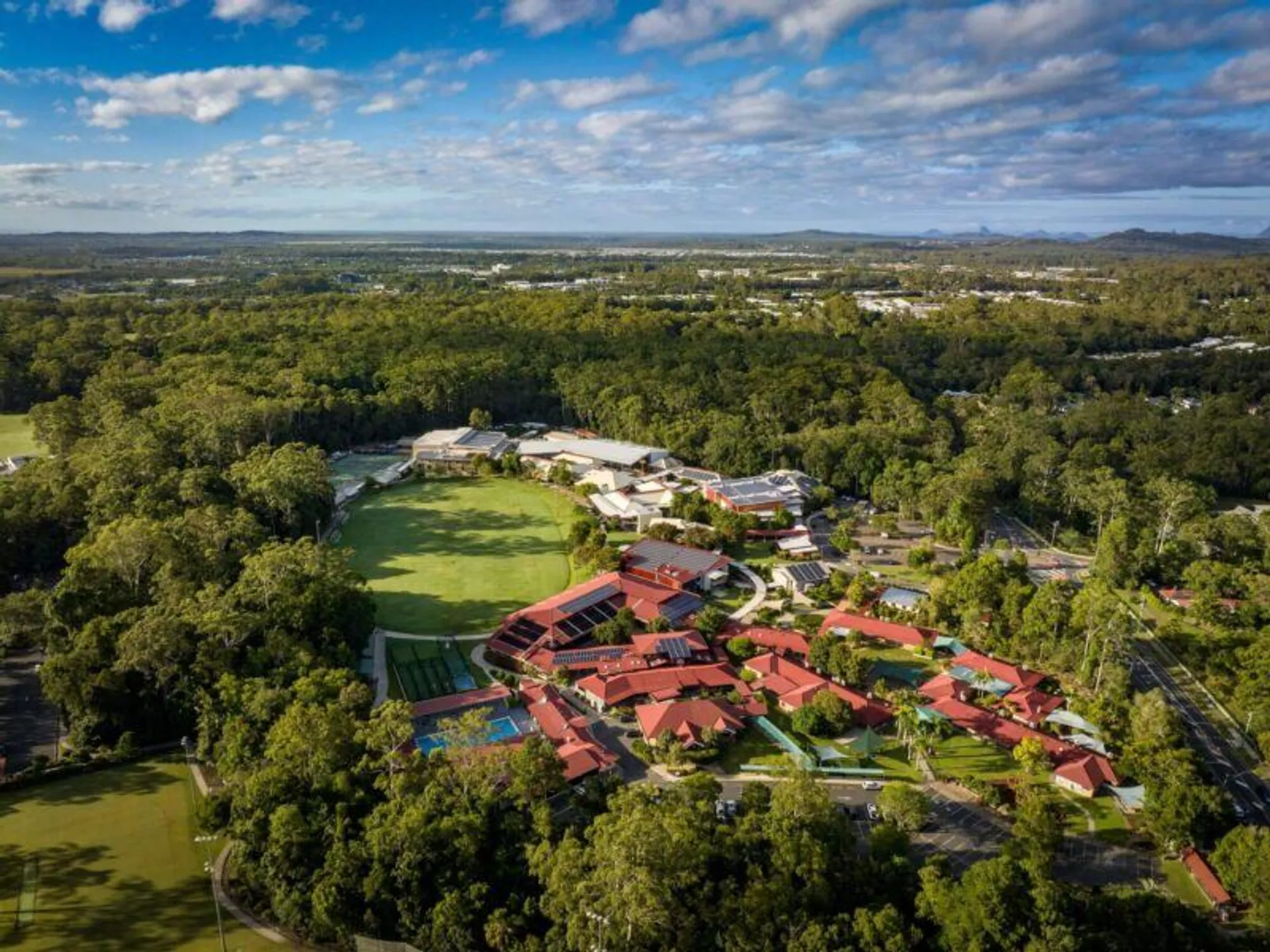 Il paesaggio verde con il Matthew Flinders Anglican College Resort e la vista sulla zona rurale con colline sullo sfondo.