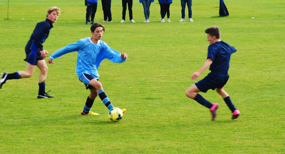 Studenti della Frensham Heights School giocano a calcio su un campo in erba.