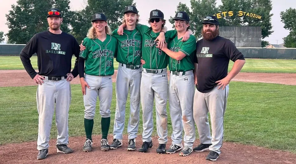 Un gruppo di cinque giocatrici e giocatori di baseball della Erle Rivers High School si trova insieme sul campo da baseball davanti a uno stadio.
