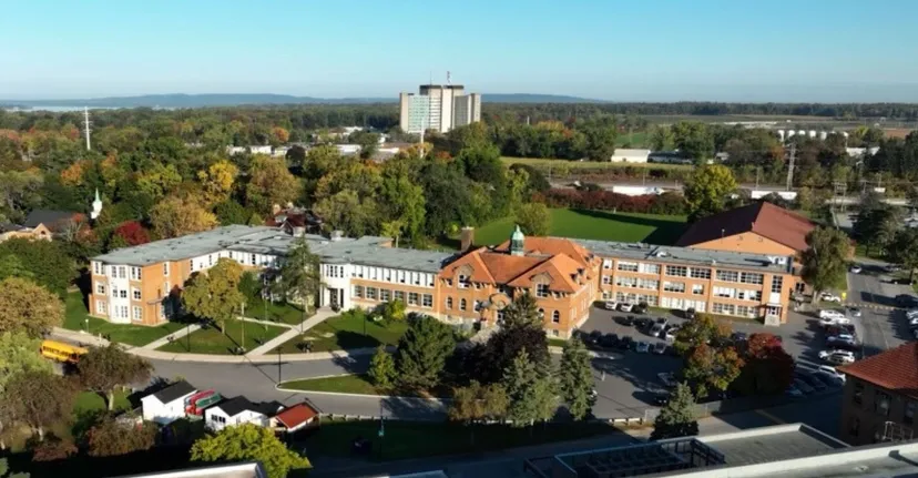 Vista aerea del campus della Macdonald High School con edifici moderni e storici immersi tra verdi colline.