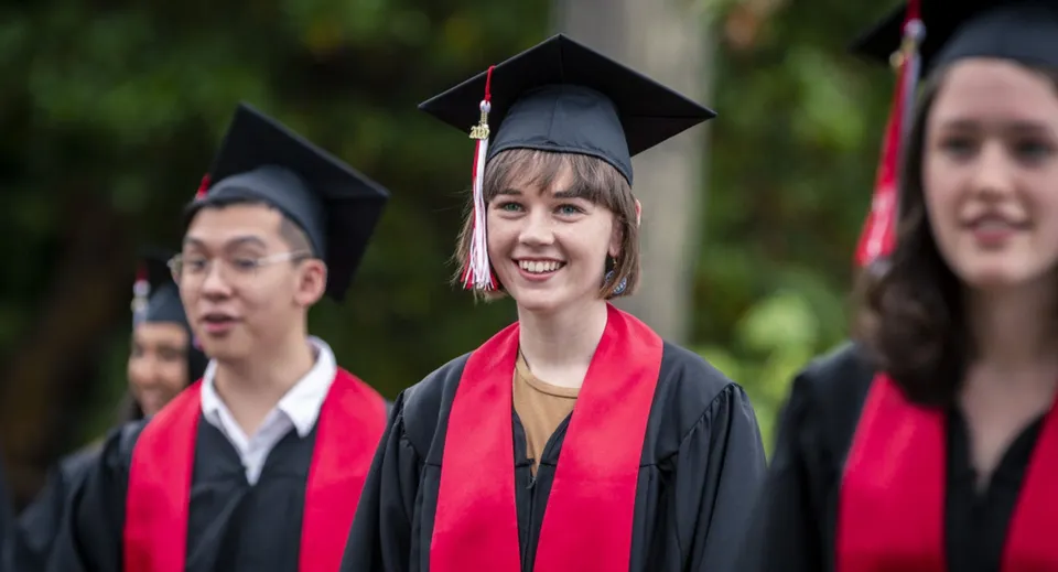 Diplomati della Brentwood College School in abito accademico su uno sfondo naturale.