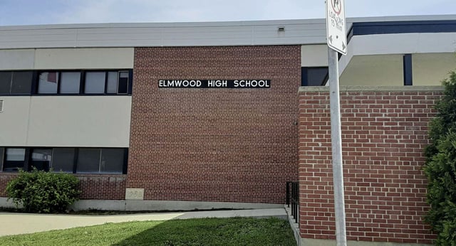 Das Backsteingebäude mit dem Schriftzug Elmwood High School ist von einer Grünfläche umgeben.