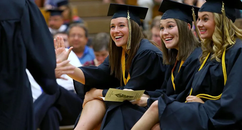 Un gruppo di giovani donne in abito da diploma festeggia il proprio successo al Loyalist Collegiate & Vocational Institute.