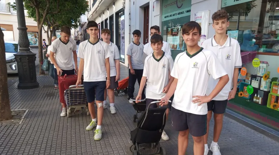 Un gruppo di studenti si trova in strada davanti a dei negozi nel terreno del Carmelitas Cadiz Colegio.