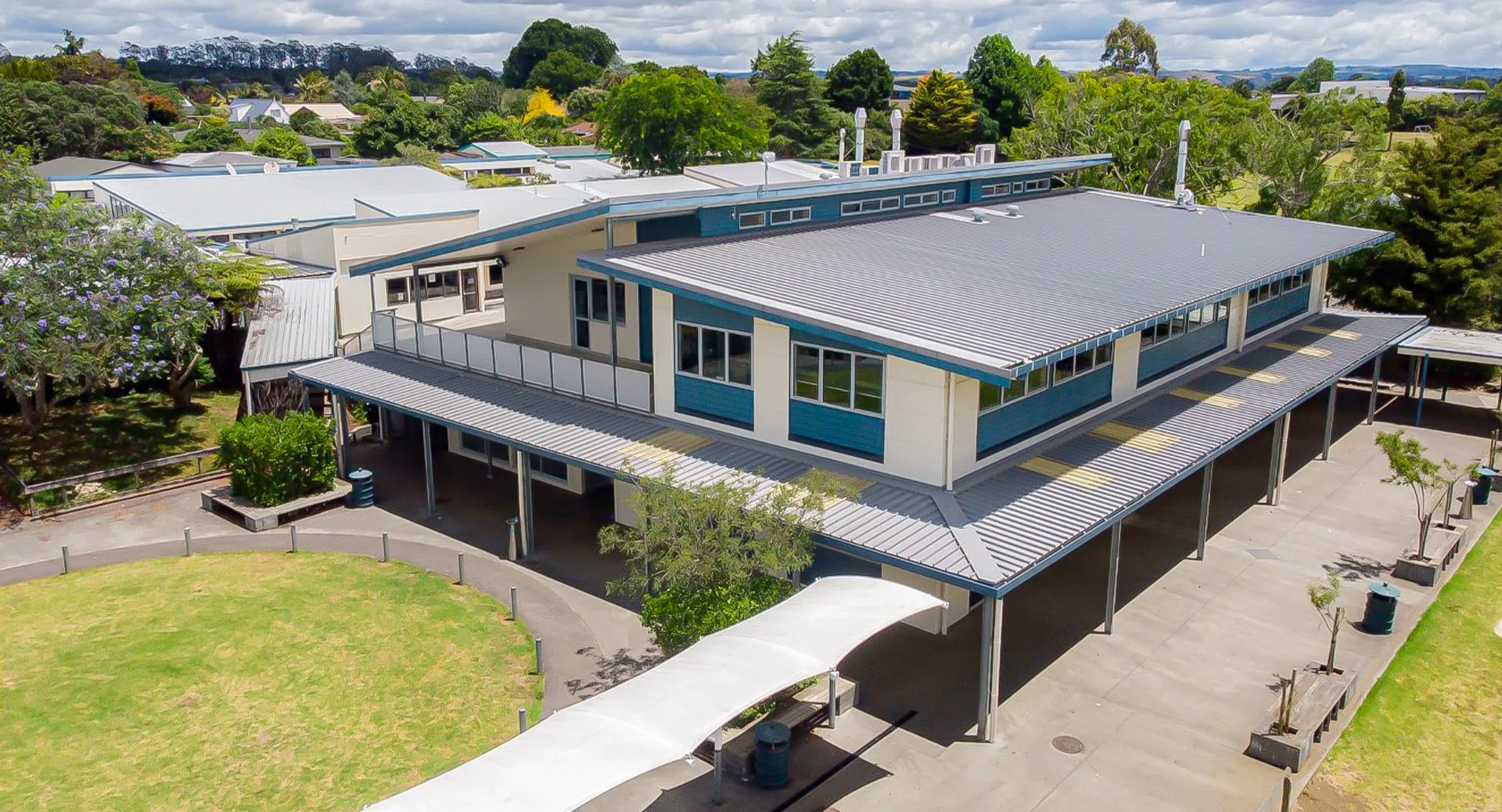 L'edificio moderno della Kerikeri High School è immerso in un paesaggio verde con alberi e vegetazione.