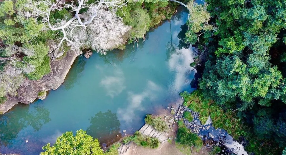 Un fiume tranquillo scorre attraverso un paesaggio verde vicino alla Kedron State High School.