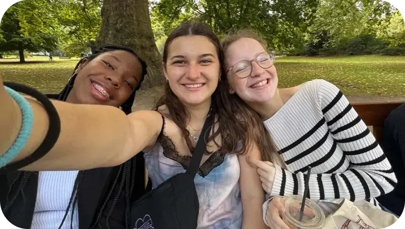 Selfie de tres chicas sonriendo bajo un árbol en un parque