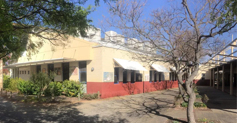 L'edificio colorato a due tonalità della Lakeland Senior High School è circondato da alberi e sorge lungo un viale pavimentato.