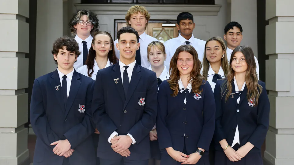 Un gruppo di studenti della Newcastle High School si trova davanti a un edificio dall'architettura tradizionale.