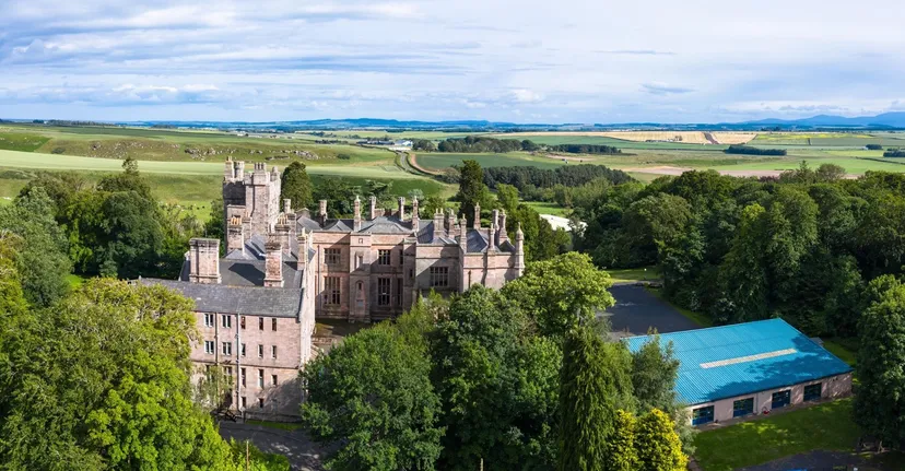 Un castello dal fascino medievale circondato da colline e paesaggi boschivi nel campus della Longridge Towers School.