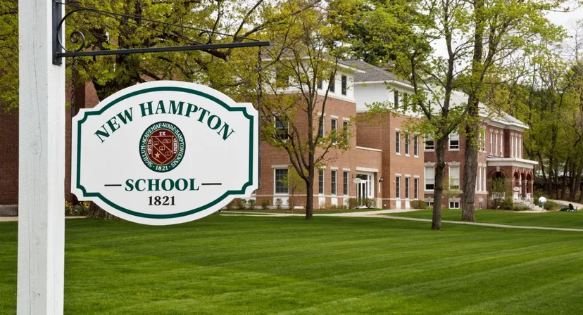 L'edificio in mattoni della New Hampton School è circondato da alberi verdi e da un prato ben curato.