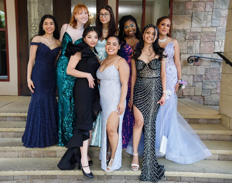 Studentesse della Bethlehem Catholic School in abiti da sera posano insieme su una scalinata in pietra.