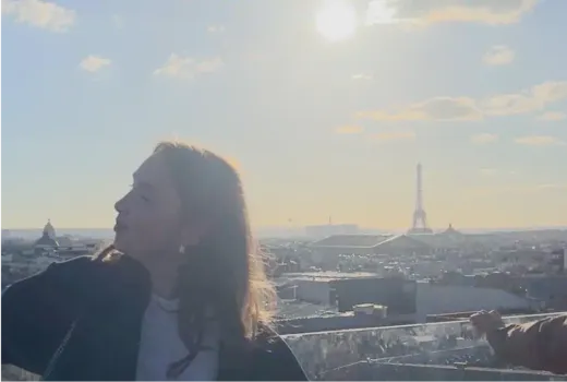 Paula im Profil auf einer Terrasse, im Hintergrund der Eiffelturm in Paris