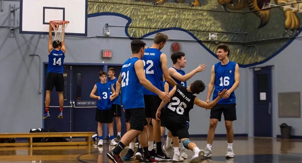 Un gruppo di studenti della Lambrick Park Secondary School si riunisce sul campo da basket durante una sessione di allenamento.