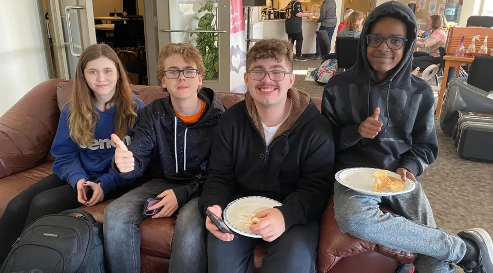 Quattro studenti della John Maland High School sono seduti insieme su un divano in un bar.