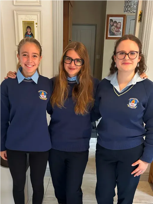 Drei Mädchen in Schuluniform lächeln gemeinsam in Irland