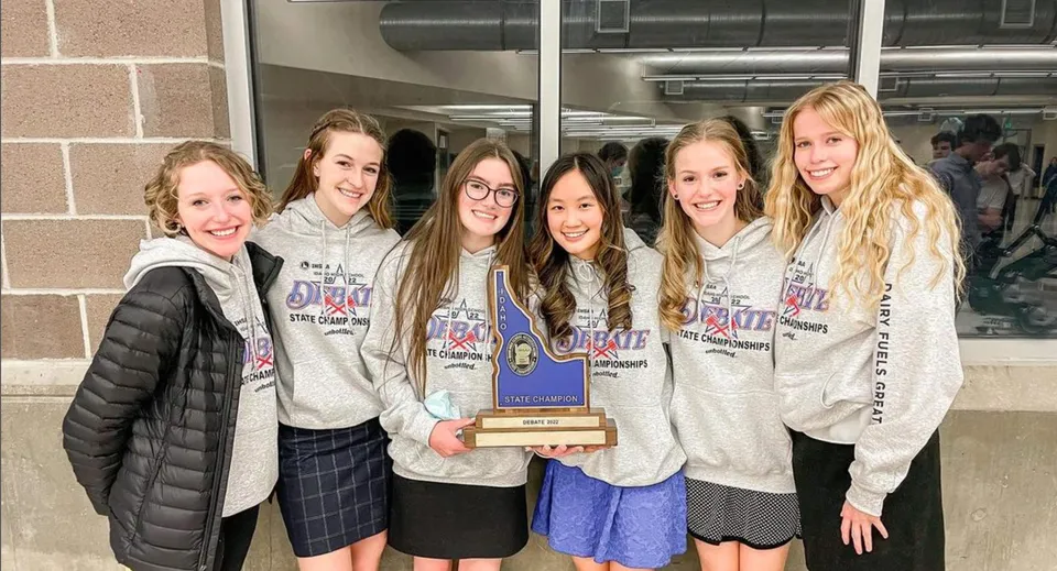 Un gruppo di studentesse del Mesa Unified School District tiene insieme un trofeo e posa in un ambiente scolastico.
