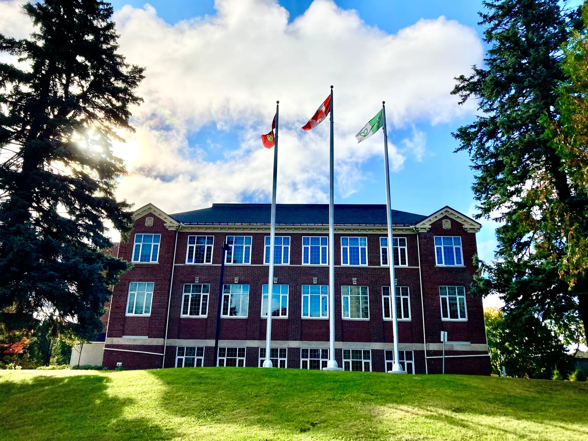 L'edificio in mattoni a più piani della École secondaire publique L'Alternative circondato da alberi in un ambiente simile a un parco.