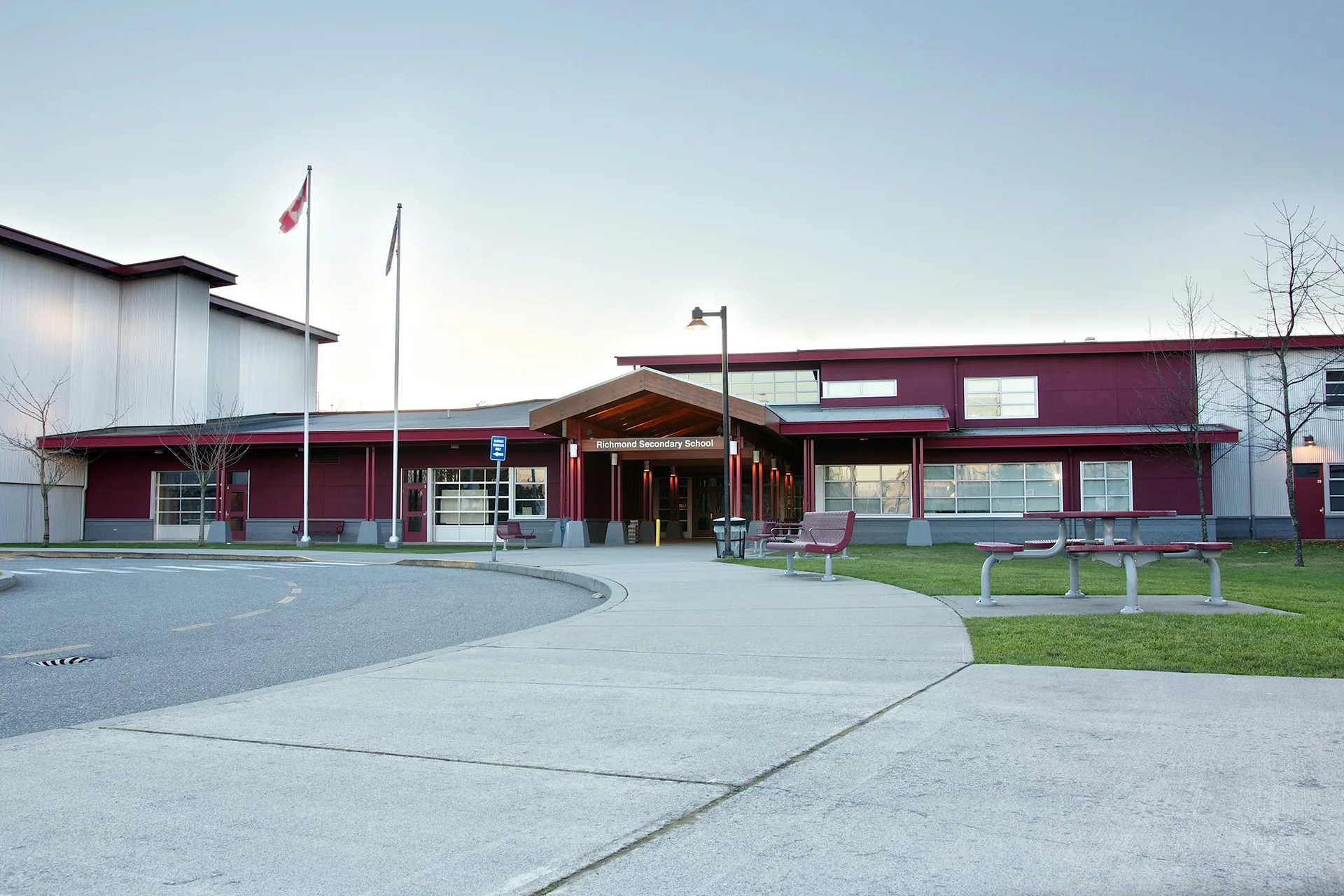 L'edificio scolastico moderno a più piani della Richmond Secondary School con la bandiera canadese all'esterno.